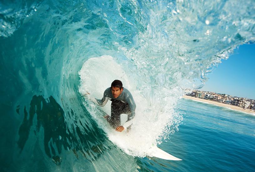 A man skillfully surfs a wave in California