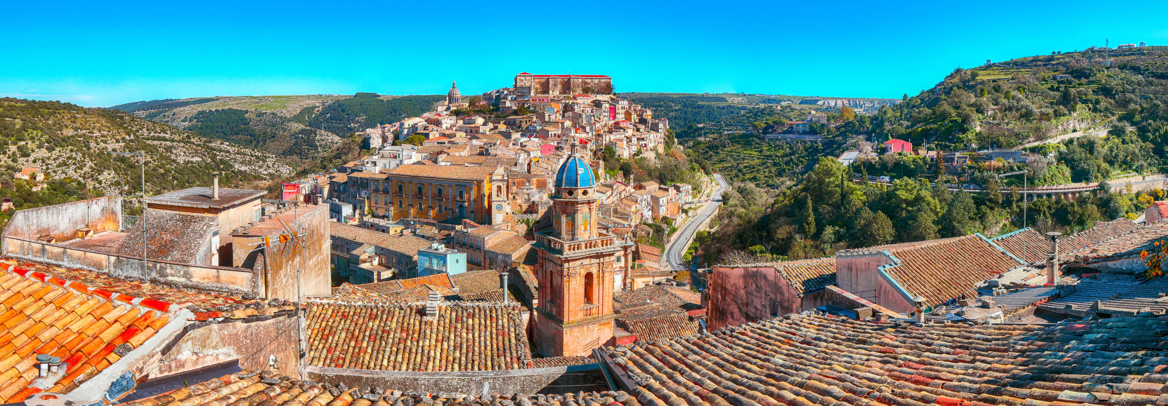 A sweeping panorama of Sant'Angelo, Italy, highlighting the town's picturesque buildings and surrounding hills