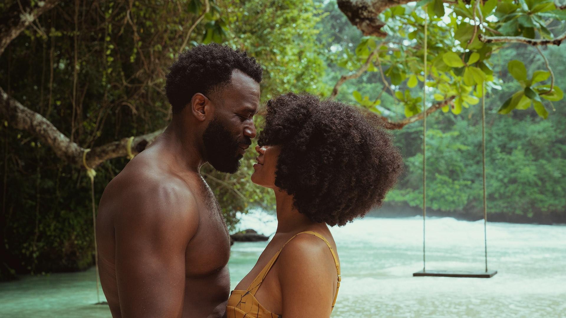 Young couple romantically canoodling in tropical setting 