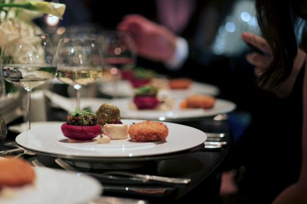 Close-up of elegant plated dishes with wine glasses at a dinner table