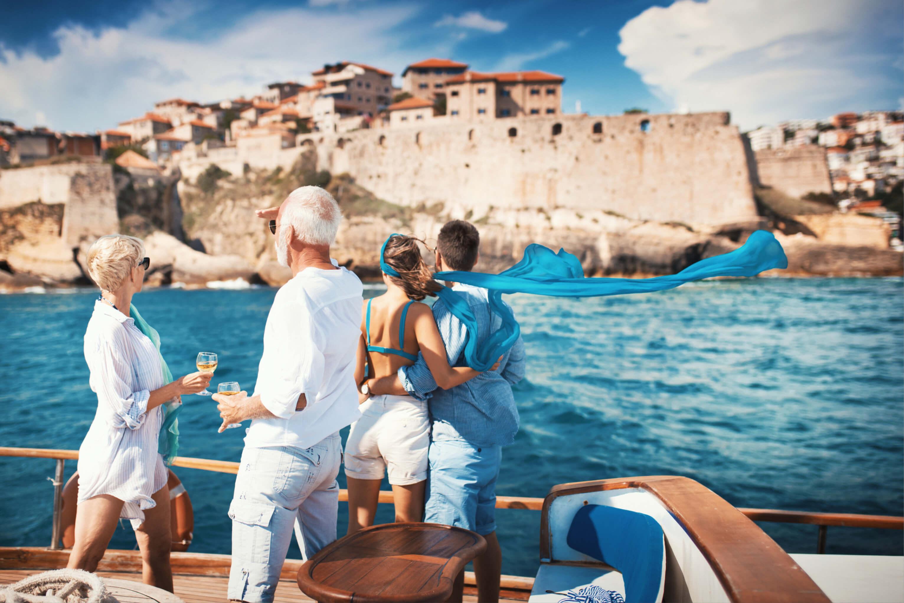 A group of people enjoying a boat ride with a scenic view of a coastal town