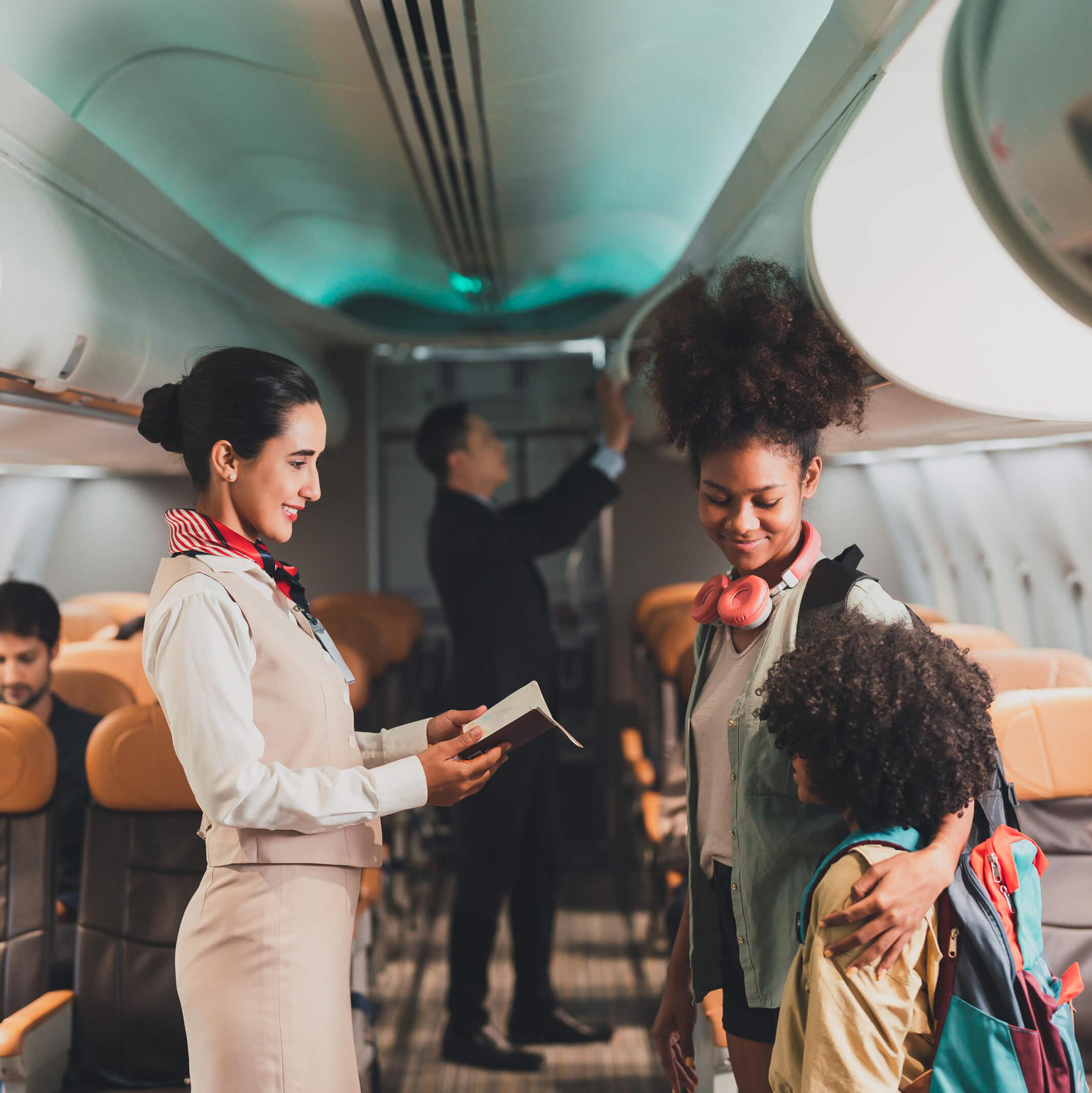 Two siblings board a plane while a flight attendant checks their passports