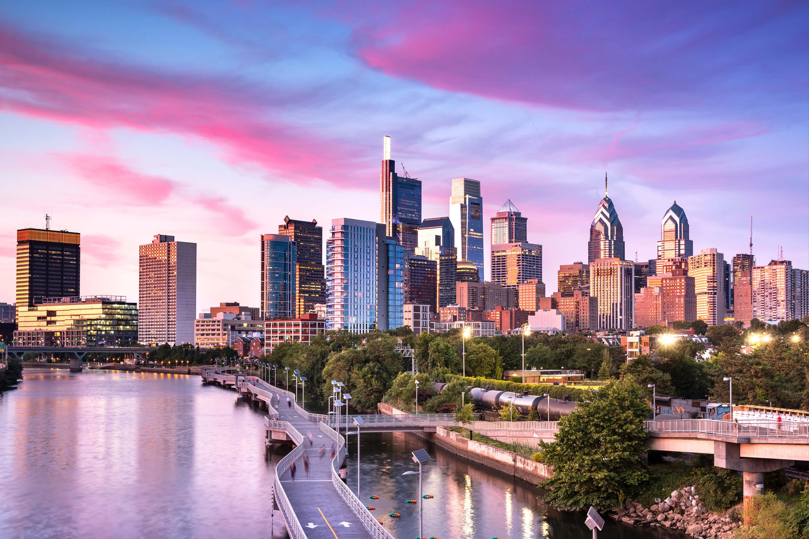 The Philadelphia skyline at sunset, showcasing a blend of skyscrapers bathed in golden and pink light
