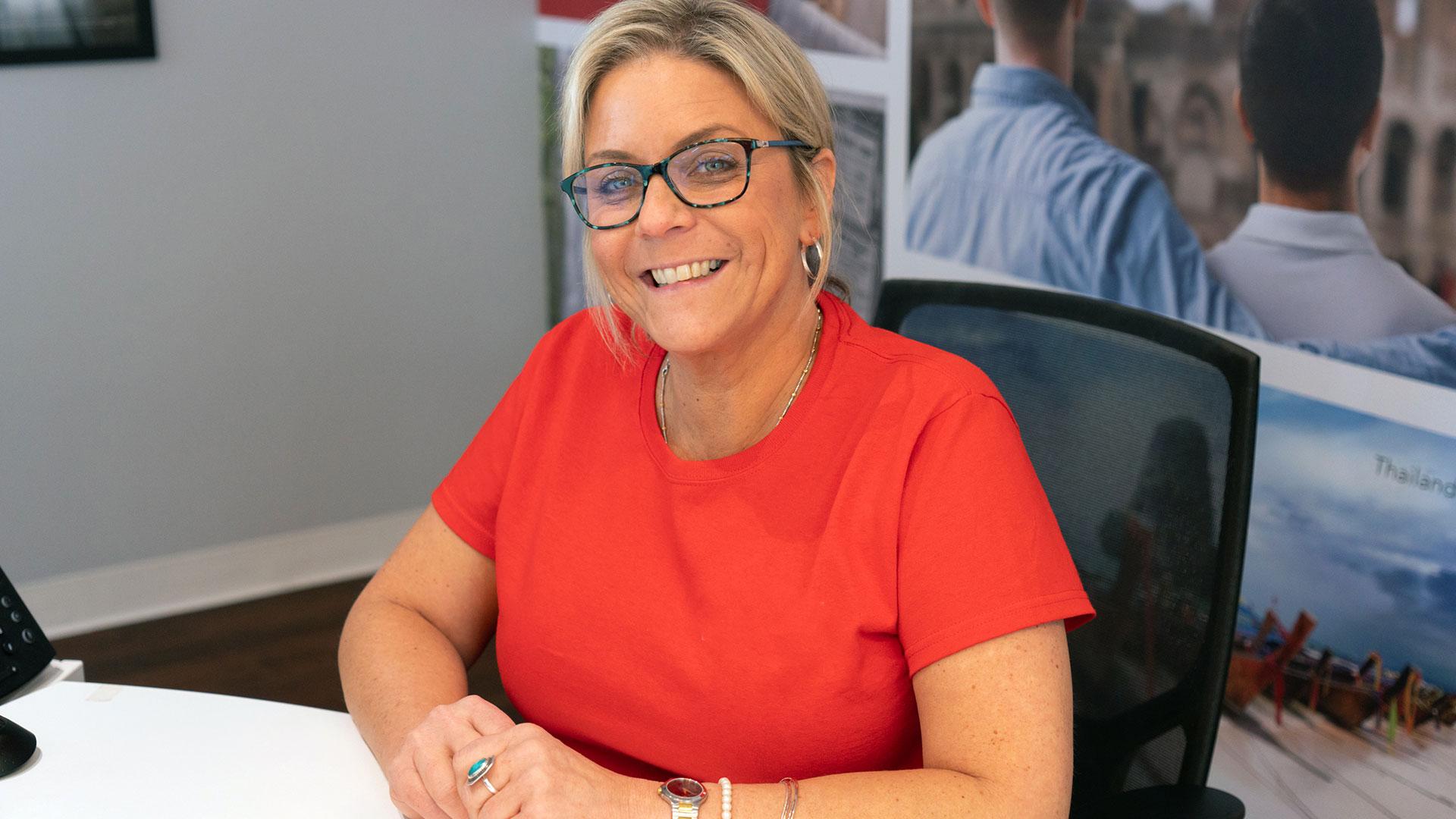 A travel advisor smiles while at her desk