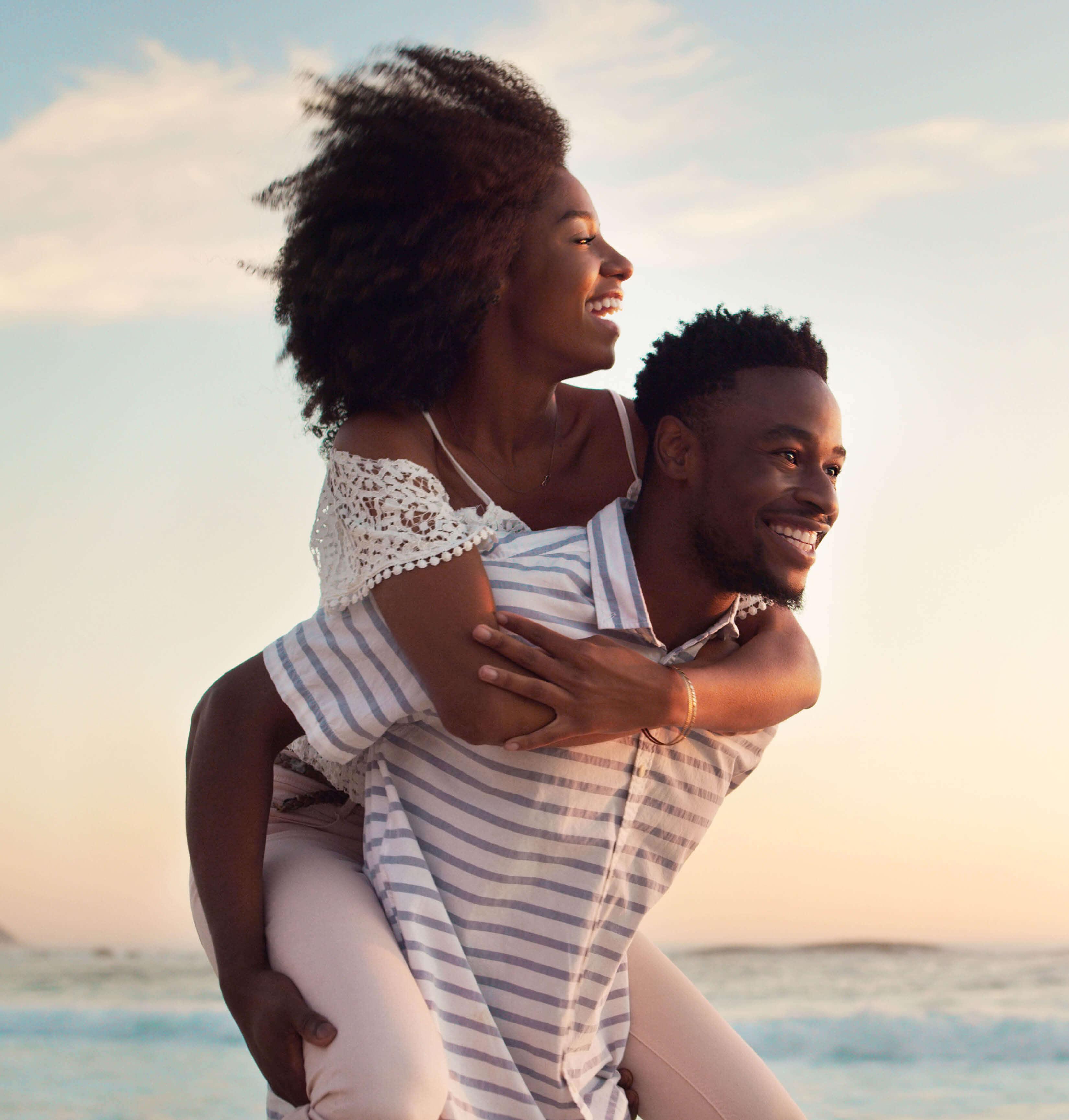 A couple walks along the ocean on vacation